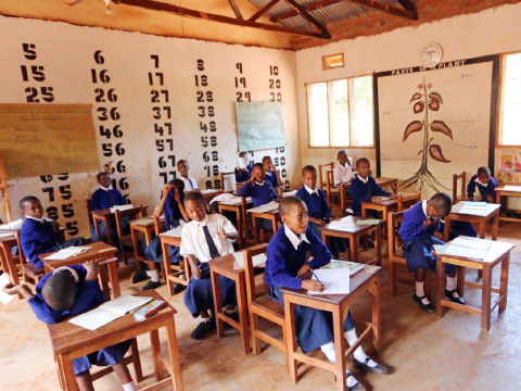 Children wearing school uniforms seated at desks in classroom